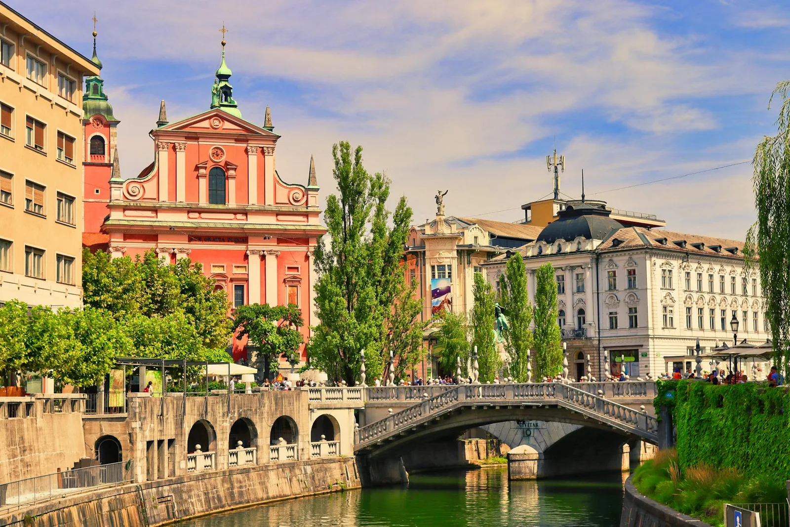 Flussufer und rosa Kirche in Ljubljana