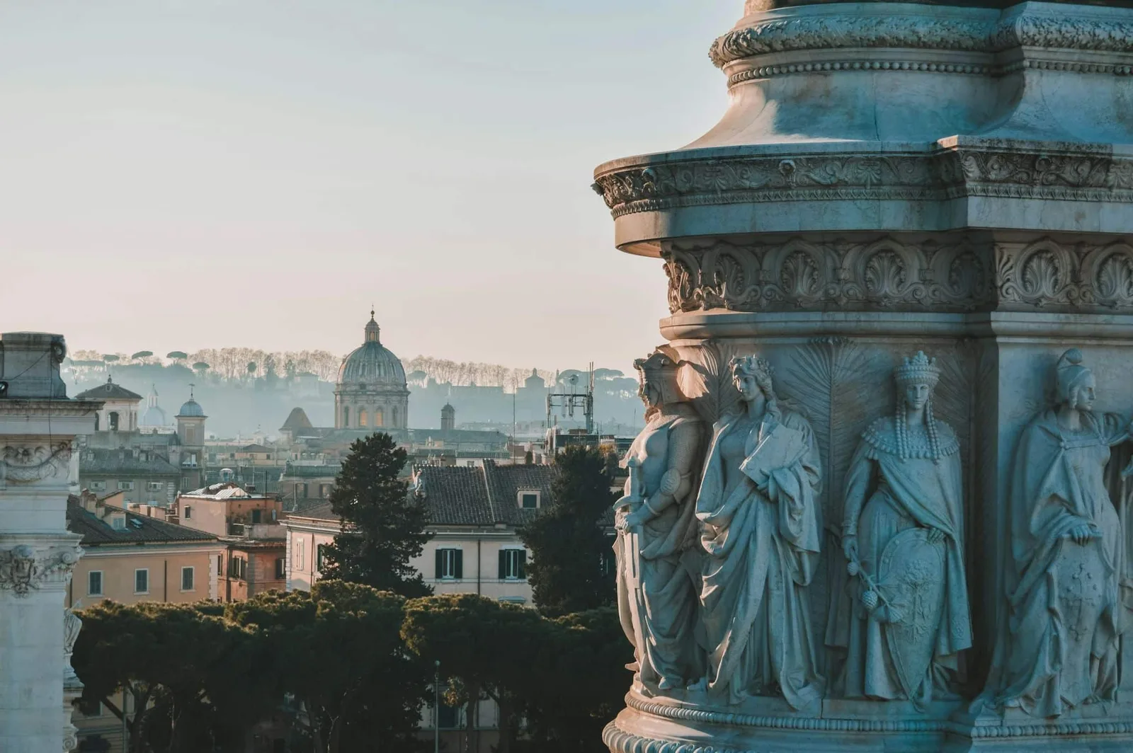Detail van een standbeeld bij het Vittoriano in Rome met de koepel van de Sint-Pietersbasiliek in de verte
