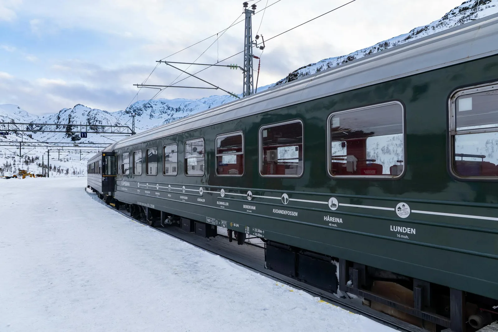 Groene Flåm Railway-trein in een besneeuwd berglandschap