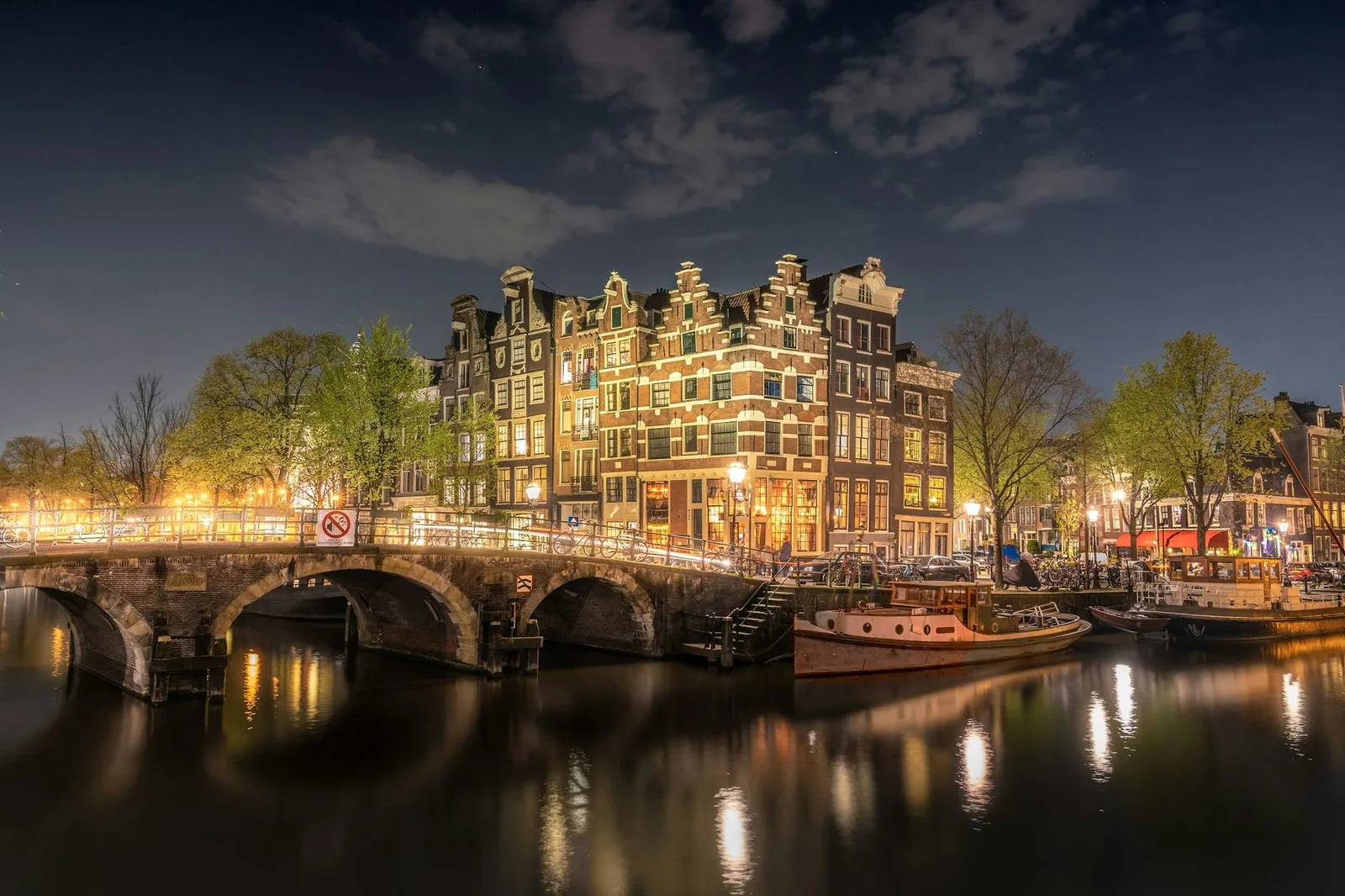 Grachtenpanden en woonboten in Amsterdam 's nachts verlicht