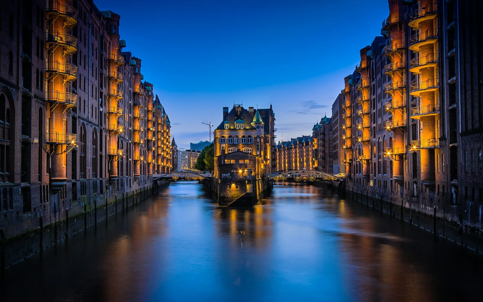 Gracht en bakstenen pakhuizen van Speicherstadt in Hamburg 's nachts