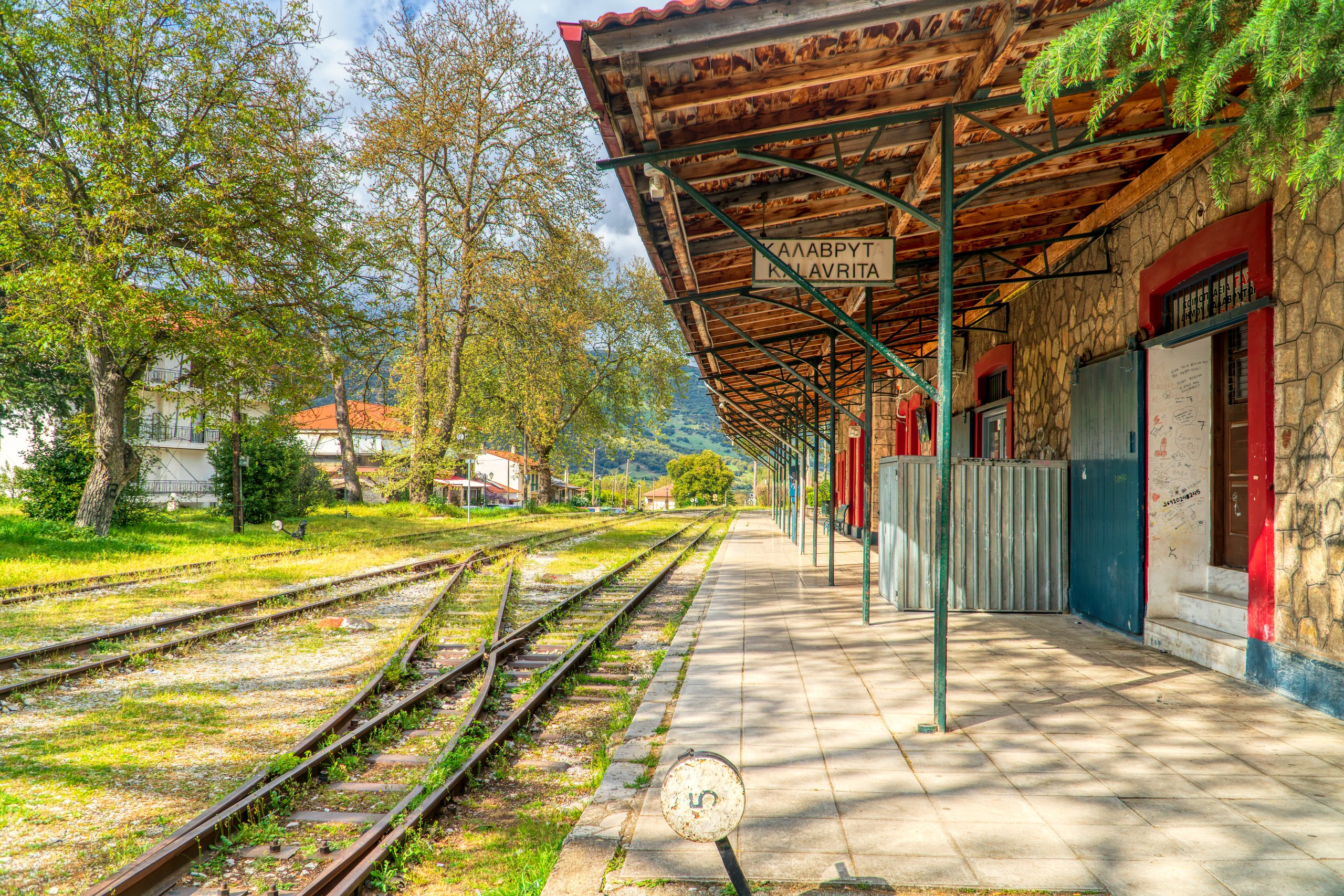 Perron en spoor van station Kalavryta, omringd door bomen in Griekenland