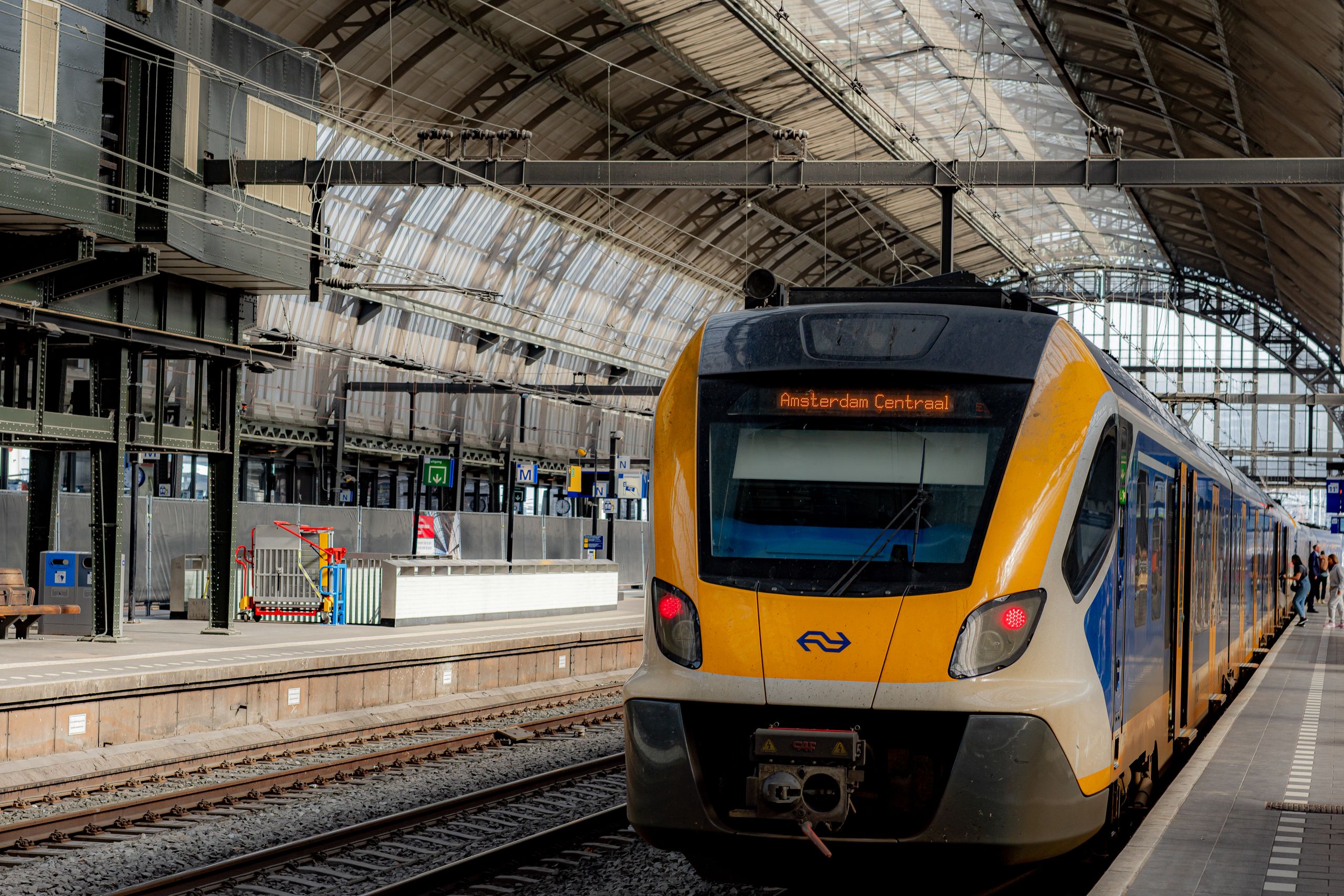 NS-trein op Amsterdam Centraal met bestemmingsscherm ‘Amsterdam Centraal’ onder het gewelfde perrondak