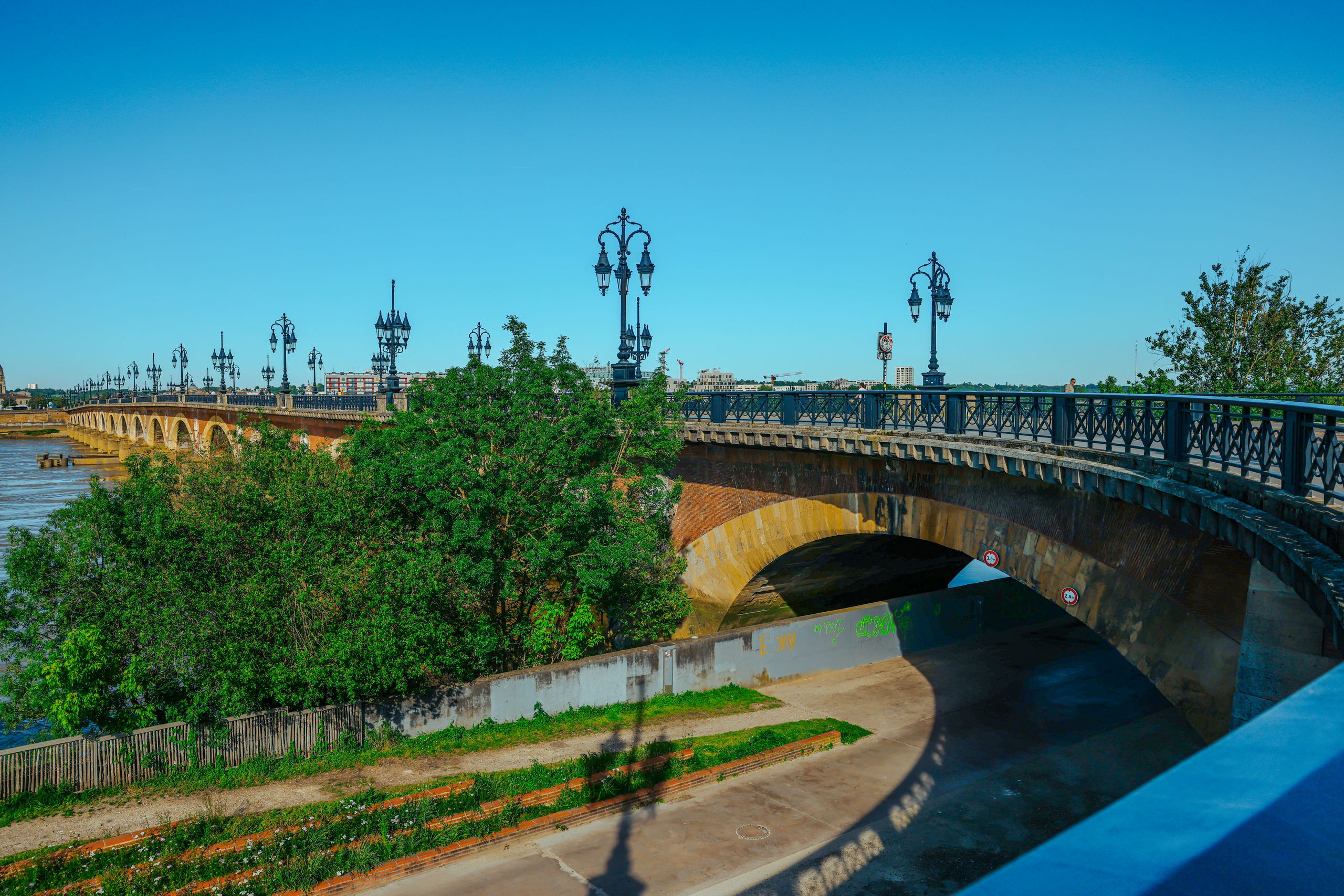 Stenen boogbrug met sierlijke lantaarnpalen over de Garonne in Bordeaux
