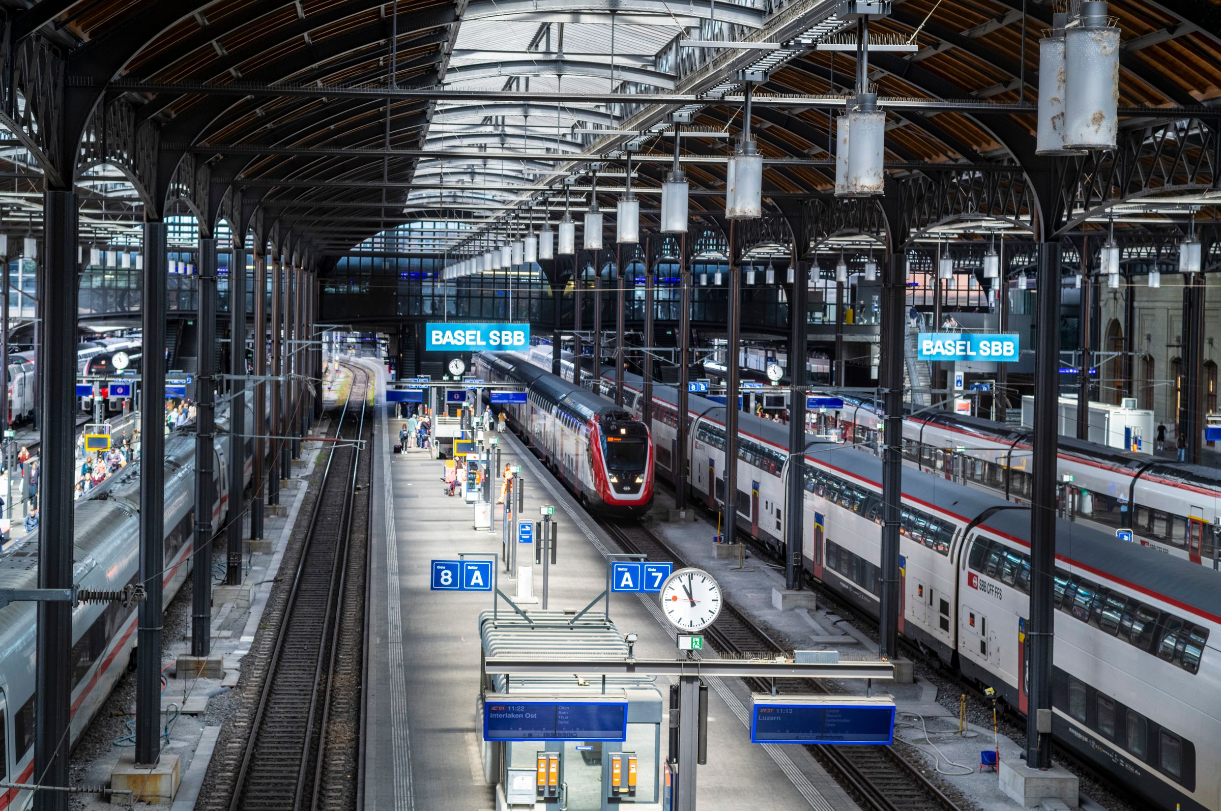 Trains at the platforms beneath the arched roof of Basel SBB station