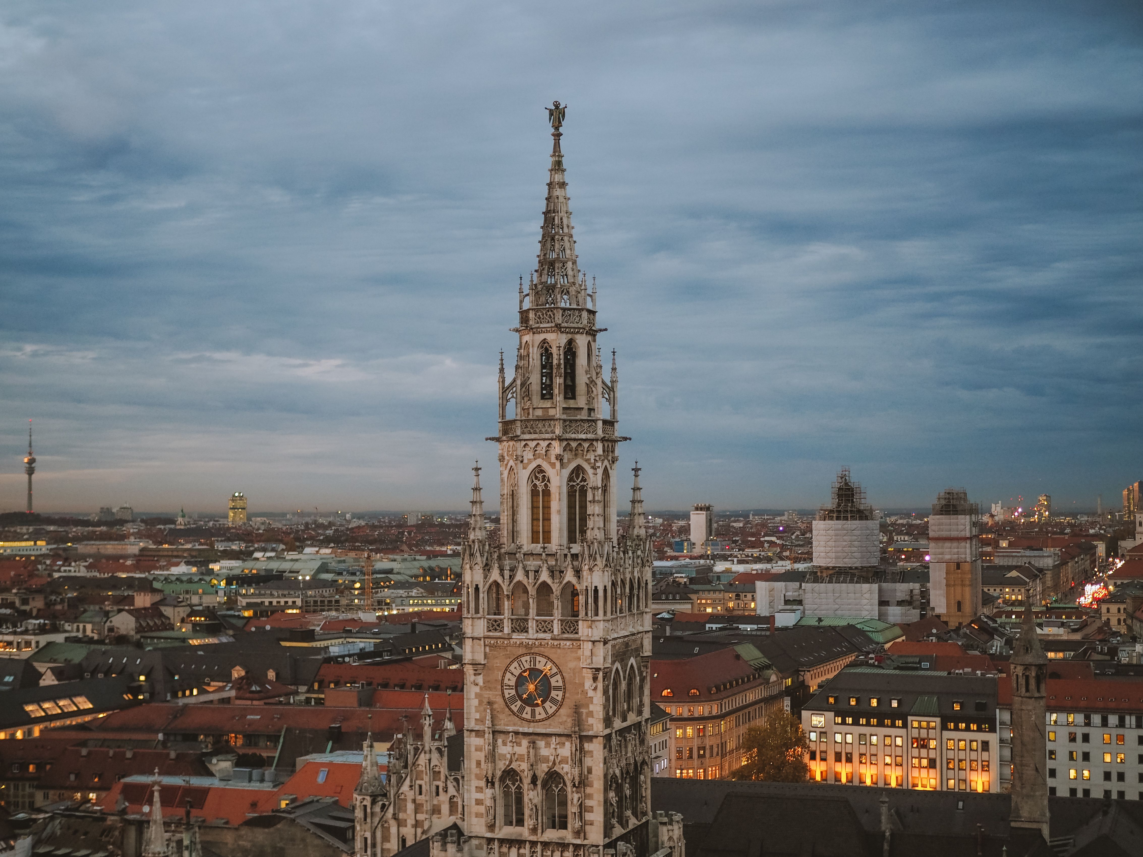 De toren van het nieuwe stadhuis van München boven de daken van de oude binnenstad in de schemering
