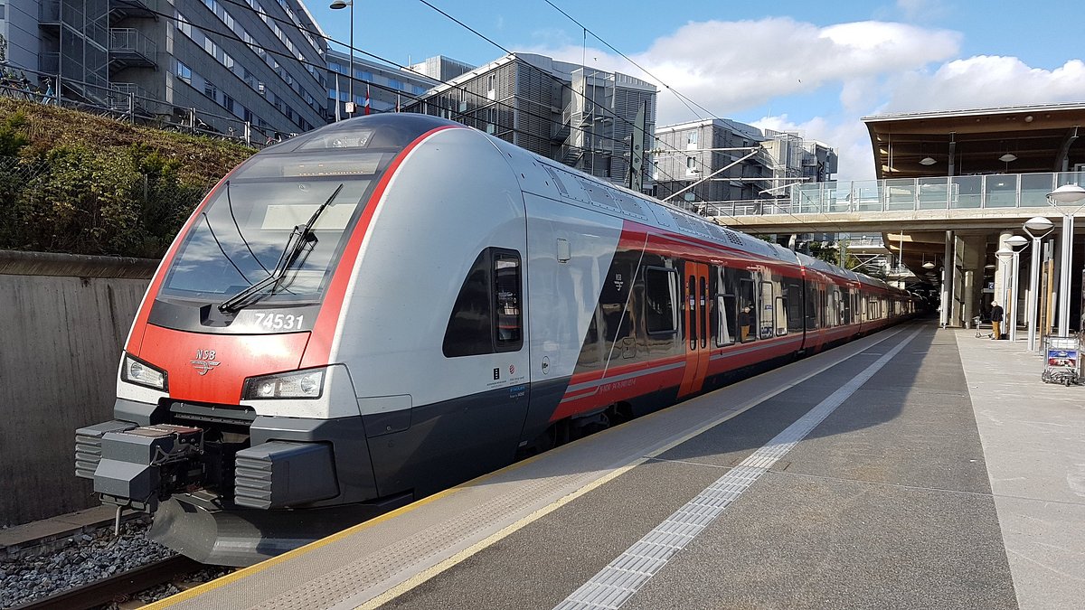 Rot-weißer Vy-Zug auf einem Bahnsteig