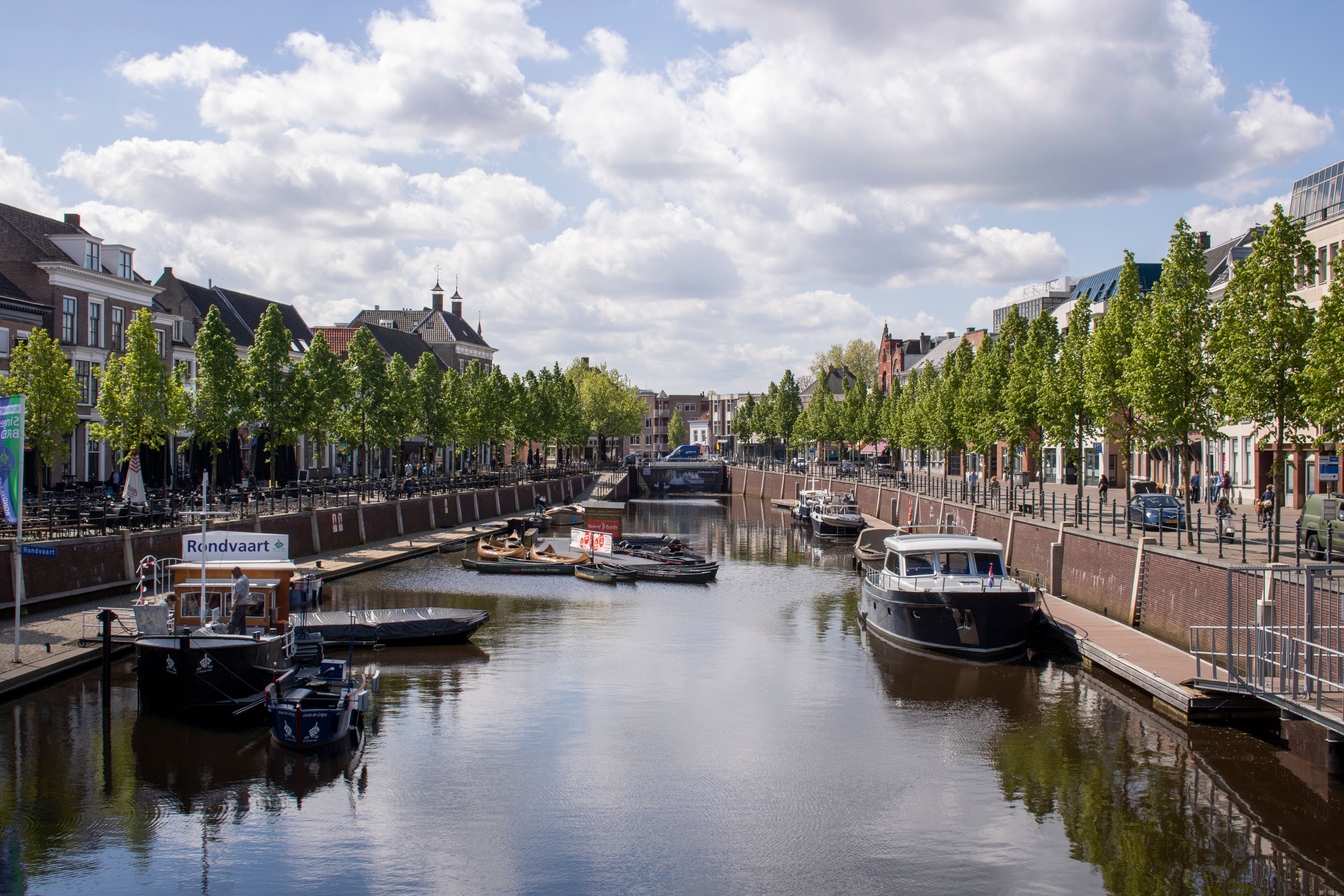 Boats moored along a tree-lined canal in the Haven district of Breda on a sunny day