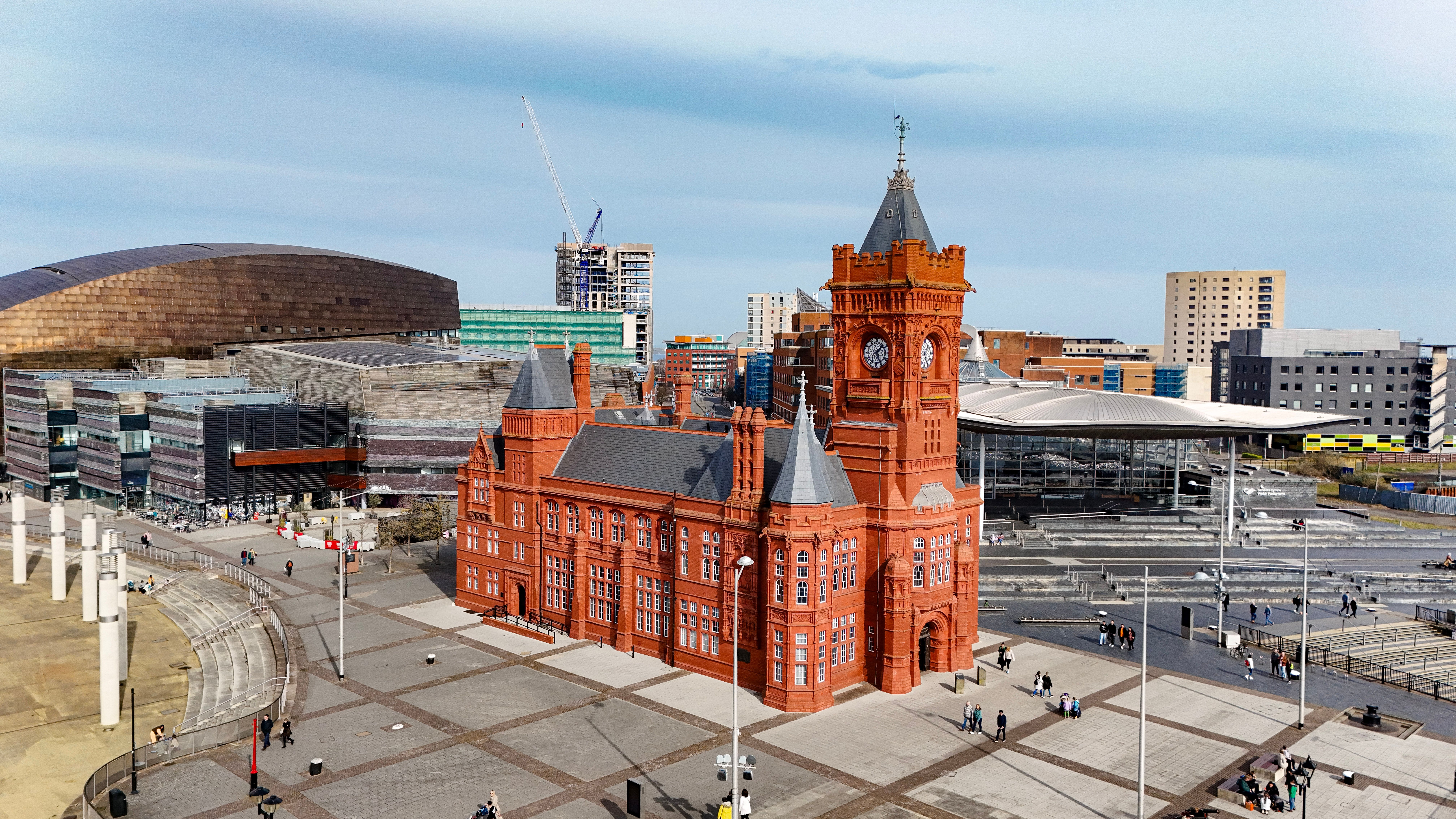 Aerial view of the red-brick Pierhead Building in Cardiff Bay, with the Wales Millennium Centre and the Senedd beside it