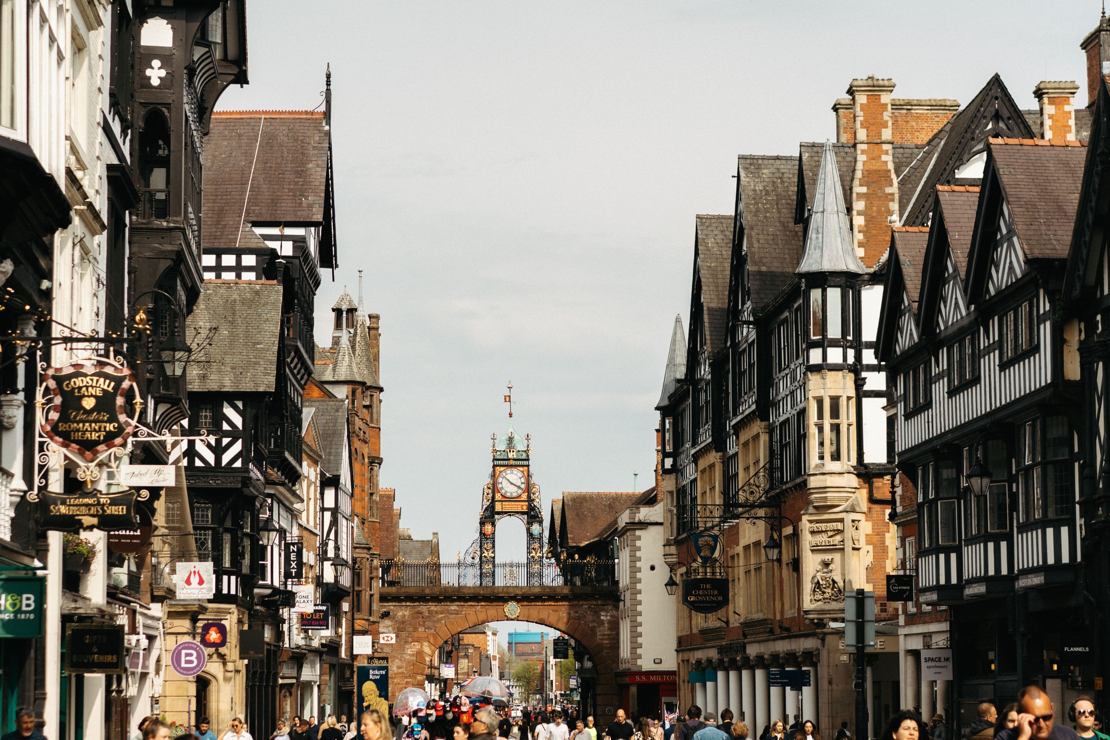 Eastgate Street i Chester kantad av svartvita korsvirkeshus, med Eastgate Clock ovanför bågen