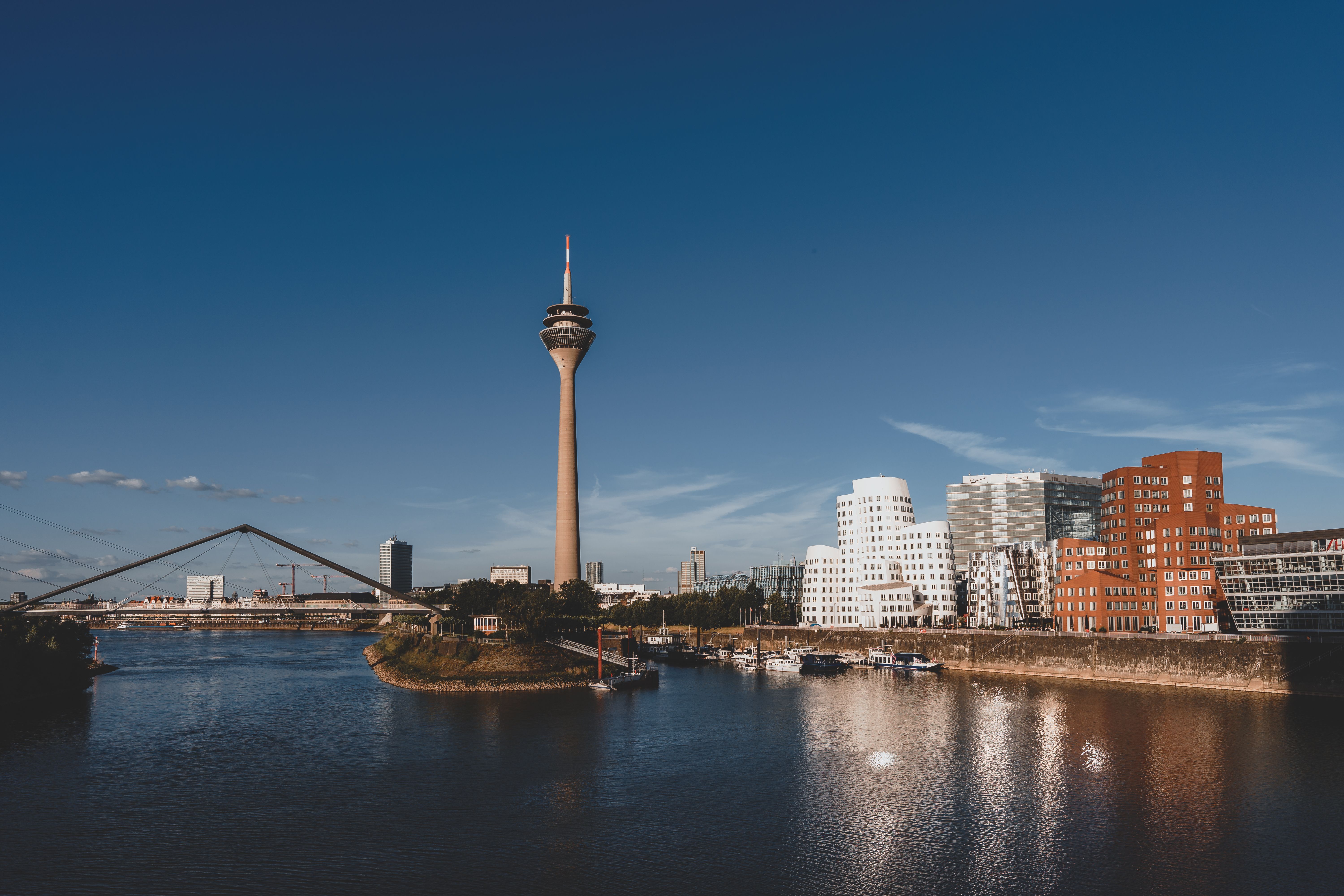 La Rheinturm e gli edifici di Gehry del MedienHafen si riflettono nel Reno a Düsseldorf nella luce del tardo pomeriggio