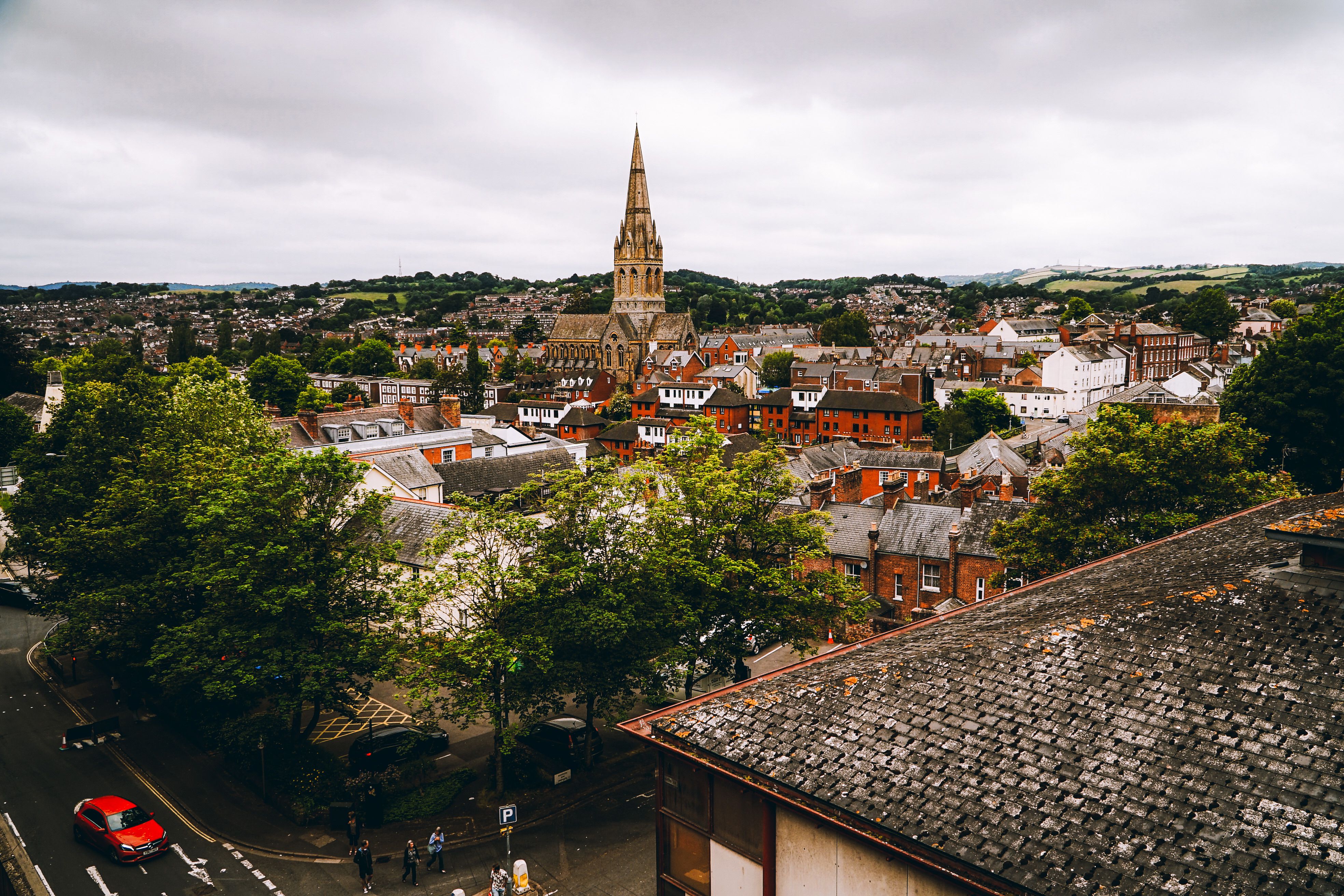 Rooftops and a church spire in Exeter seen from a high viewpoint under a grey sky