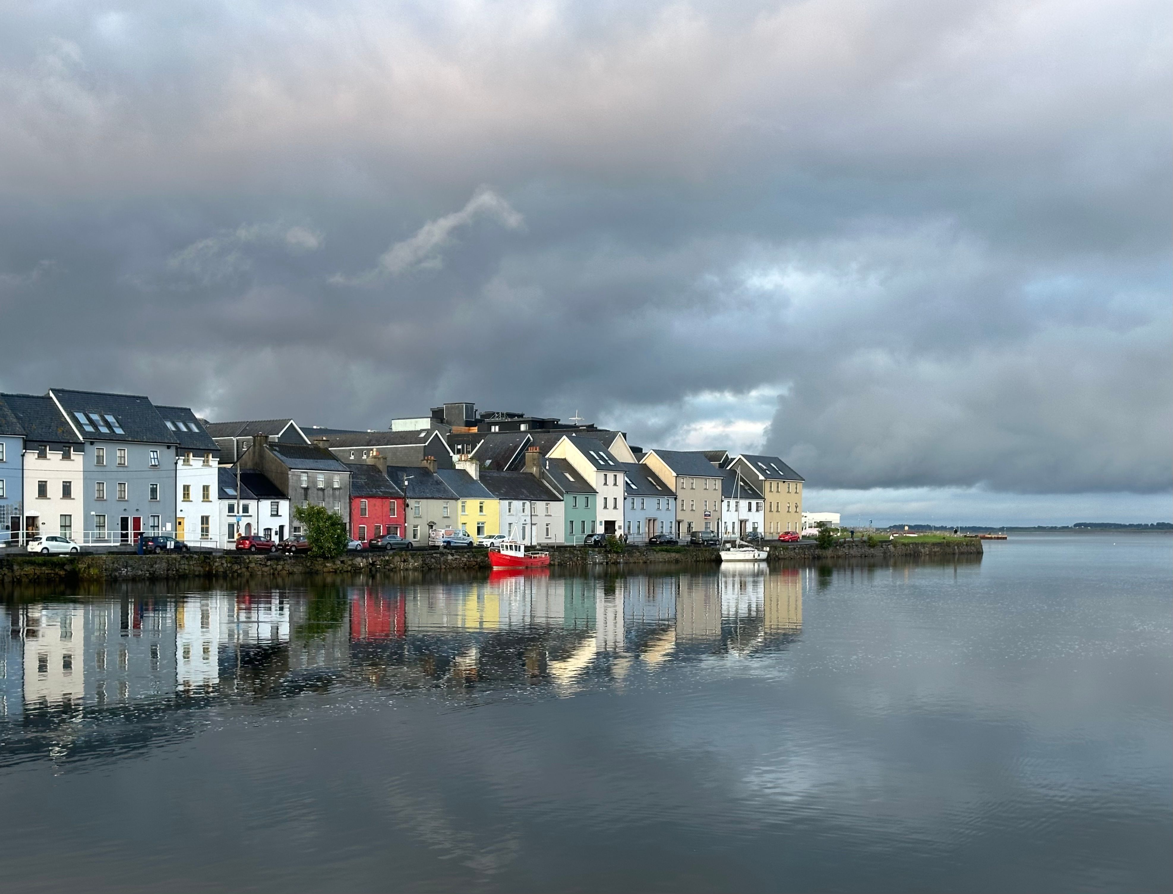 Bunte Reihenhäuser an der Long Walk, die sich im Wasser bei Galway in Irland spiegeln