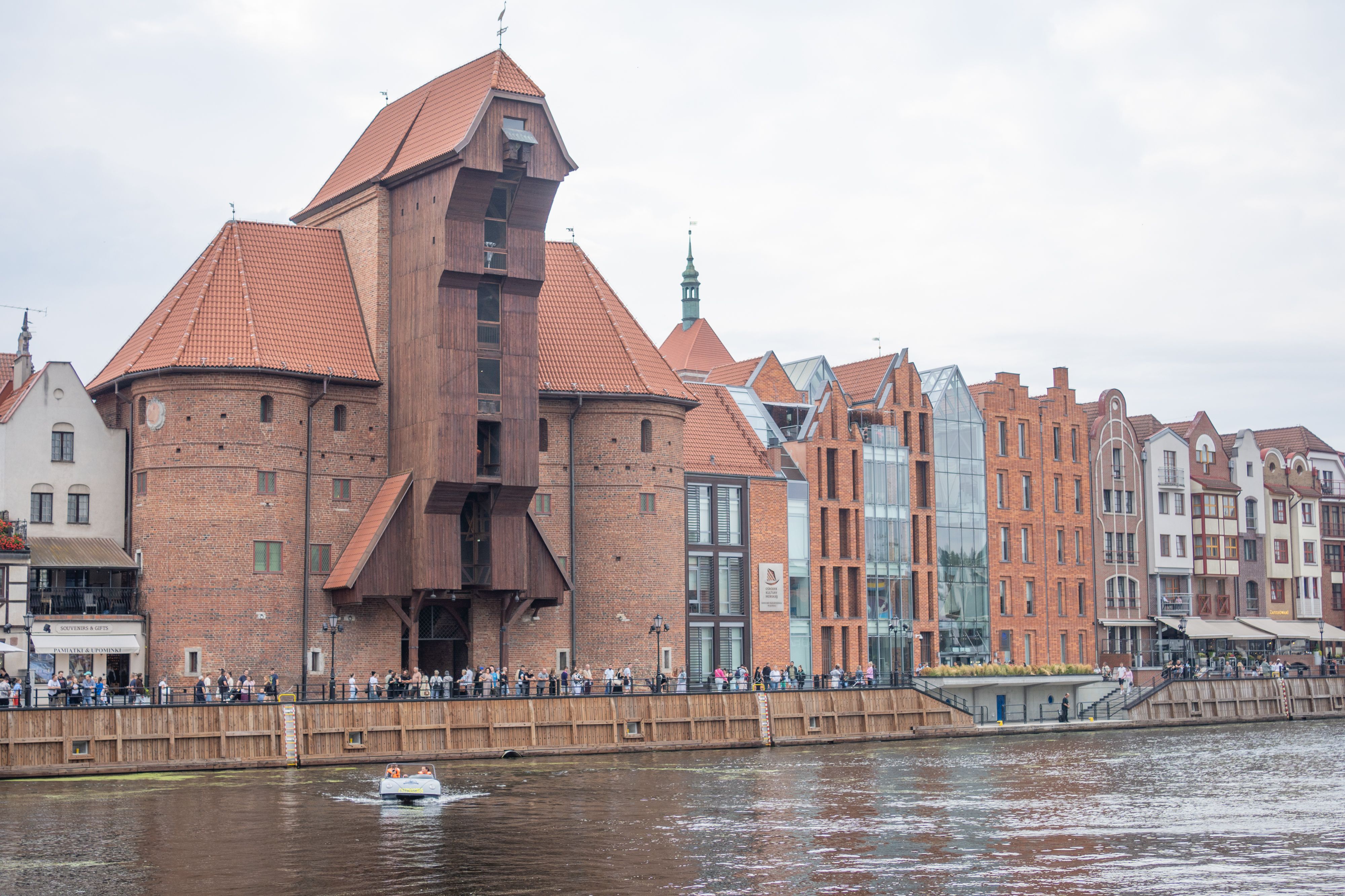 La grue médiévale (Żuraw) au bord de la Motława à Gdańsk, avec des maisons de briques à pignons sur le quai