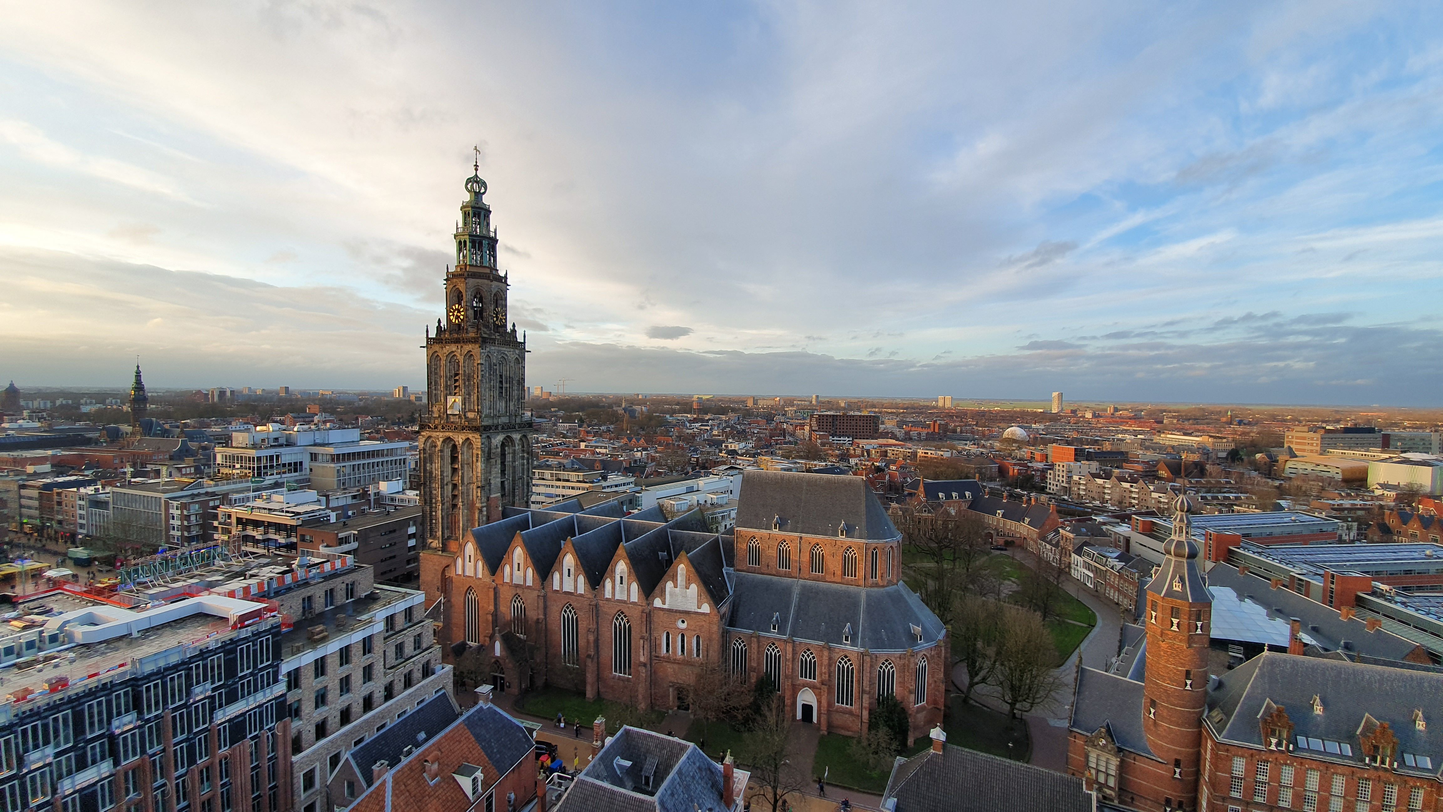 Aerial view of the Martinitoren and Martinikerk rising above the rooftops of Groningen at dusk