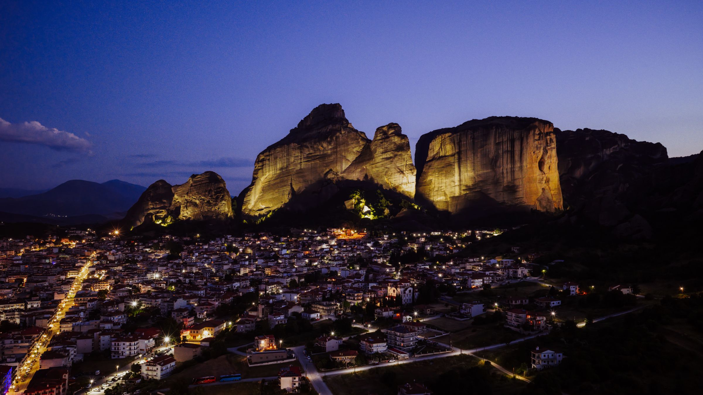 Piliers rocheux des Météores illuminés au-dessus de la ville de Kalambaka, en Grèce, au crépuscule