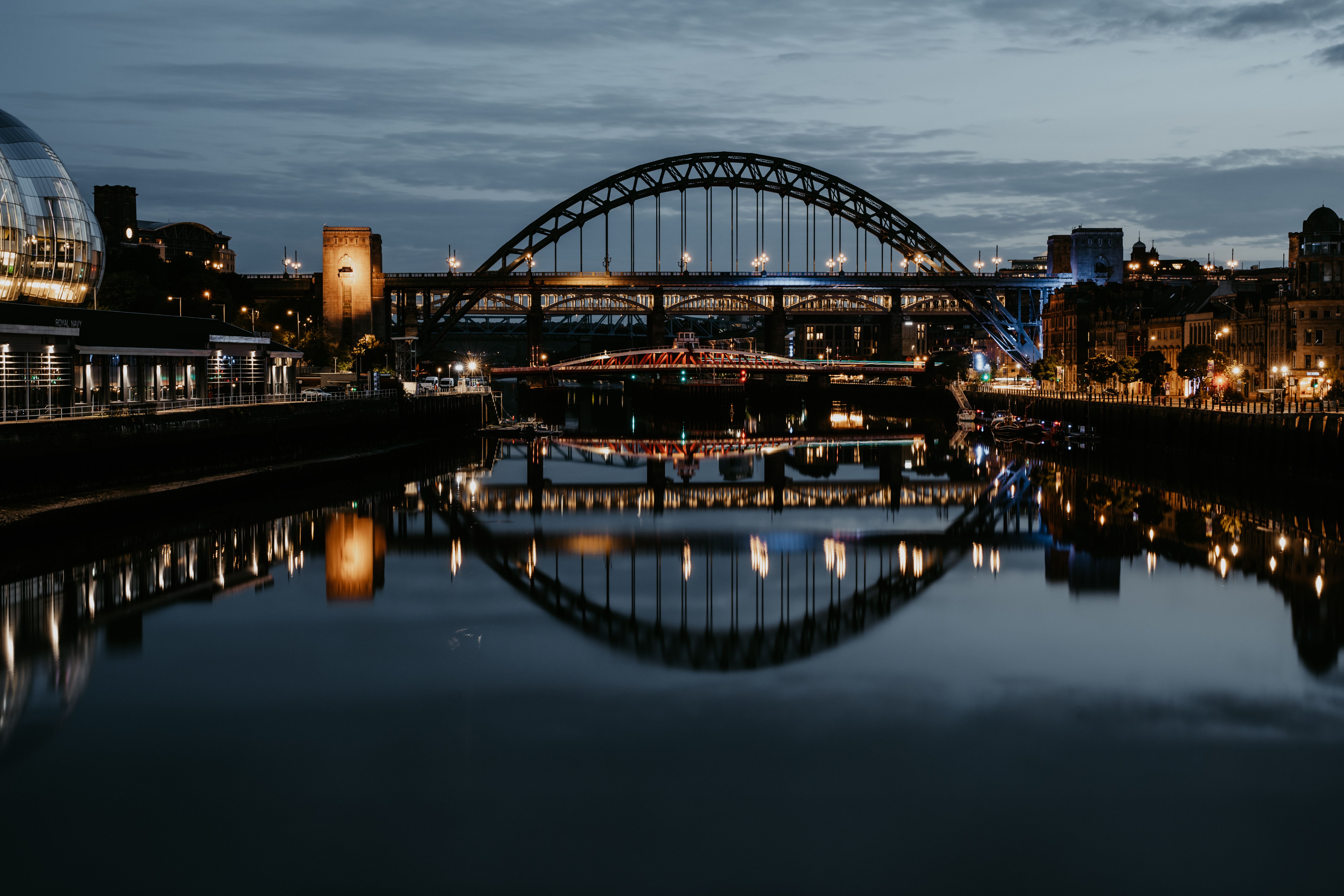 Tyne Bridge och Swing Bridge speglar sig i River Tyne i skymningen, Quayside i Newcastle