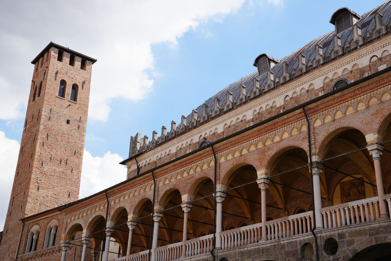 Historic brick arcades and a tower in Padua.