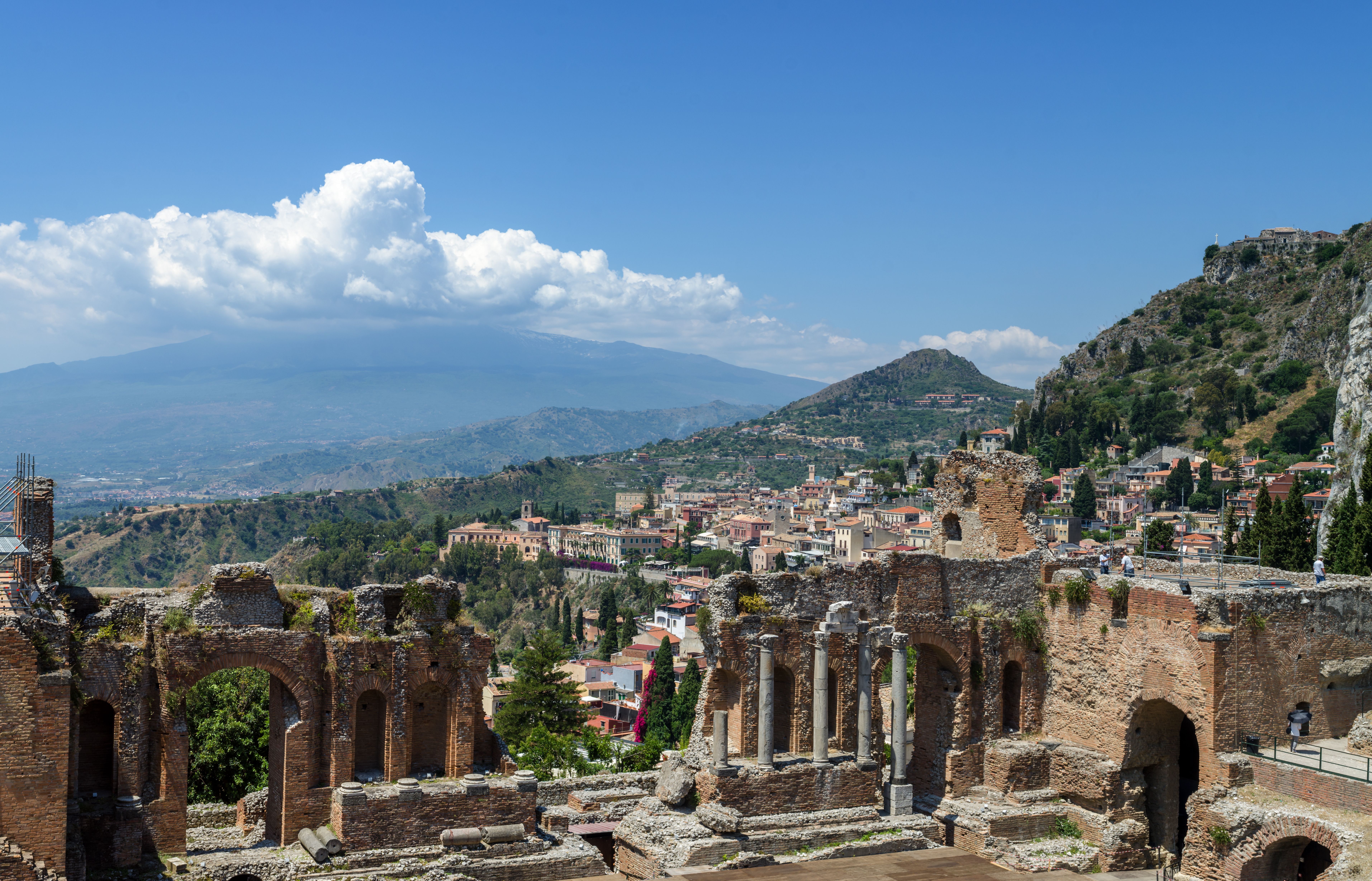 Ruïnes van het antieke theater van Taormina met het stadje beneden en de Etna aan de horizon
