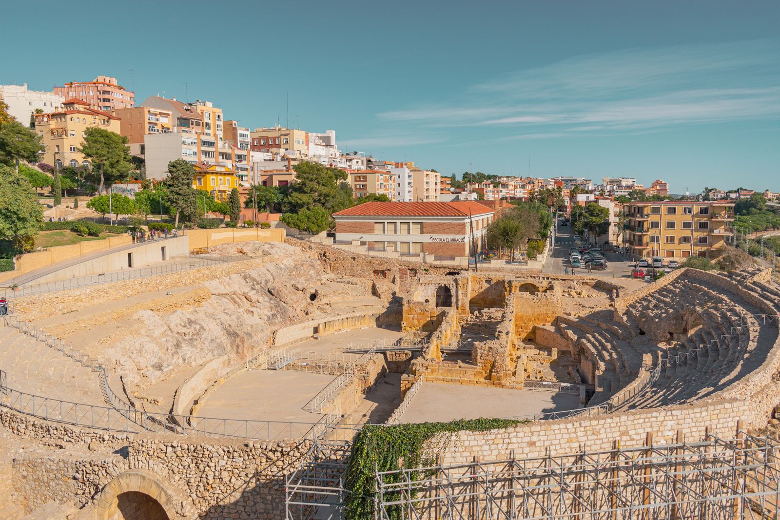 Tarragona's Roman amphitheatre with city buildings behind it.