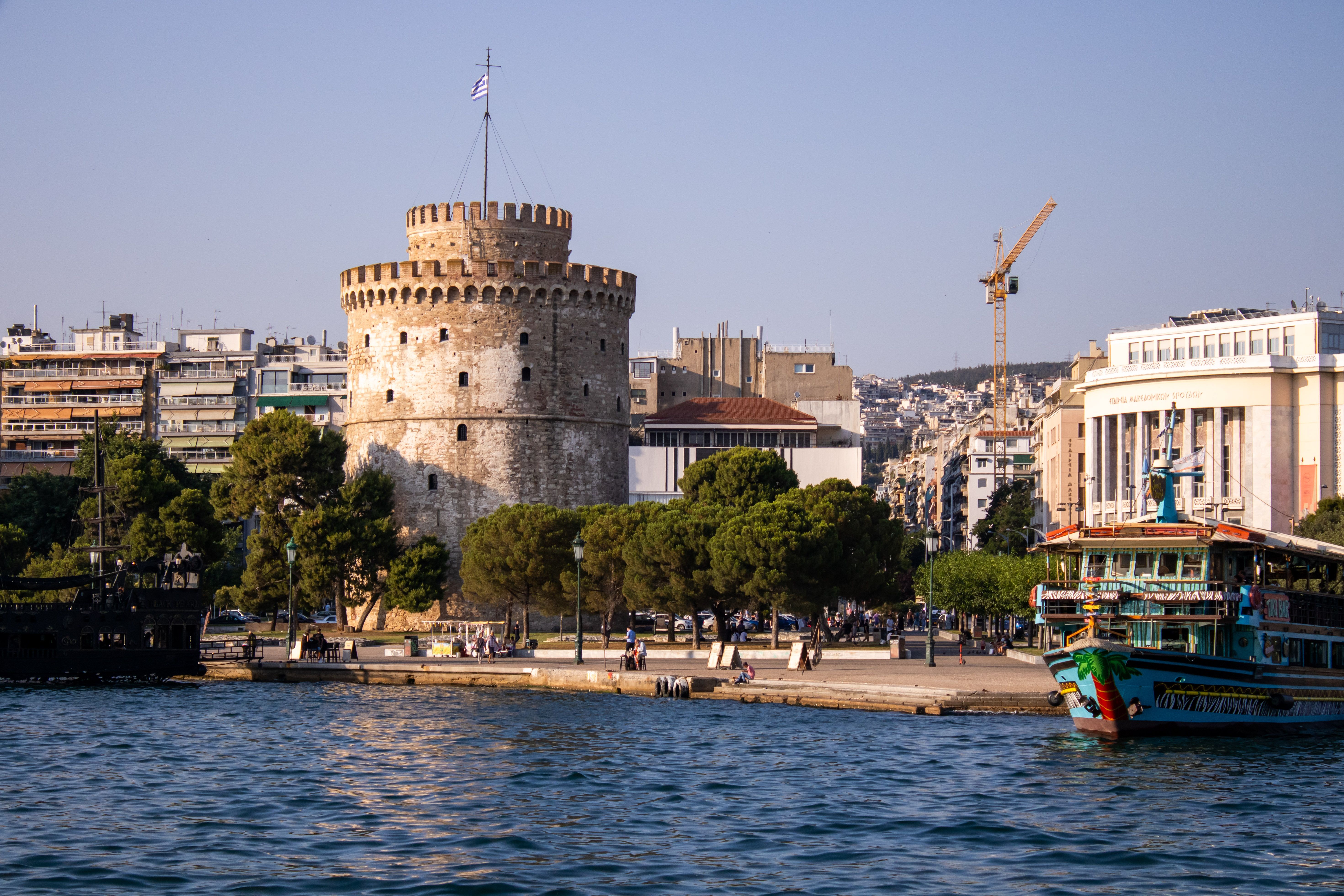 La Tour Blanche sur le front de mer de Thessalonique dans la lumière du soir, avec la promenade et un bateau d'excursion