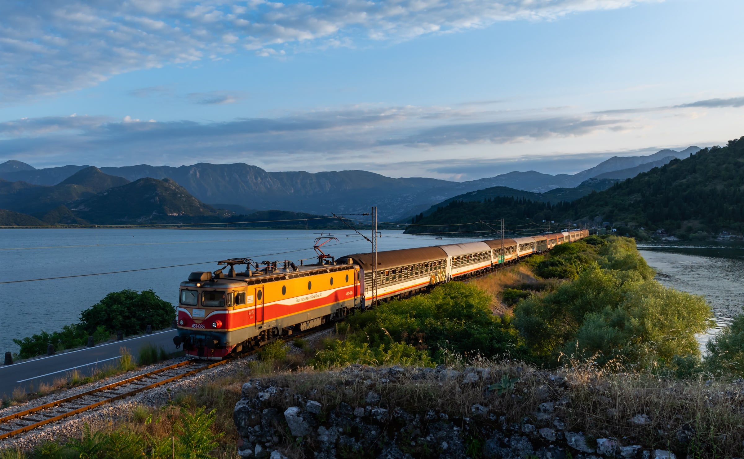 Una locomotiva elettrica ŽPCG della serie 461 traina un treno sul terrapieno di Lesendro, sul lago di Skadar, lungo la linea da Bar a Podgorica in Montenegro
