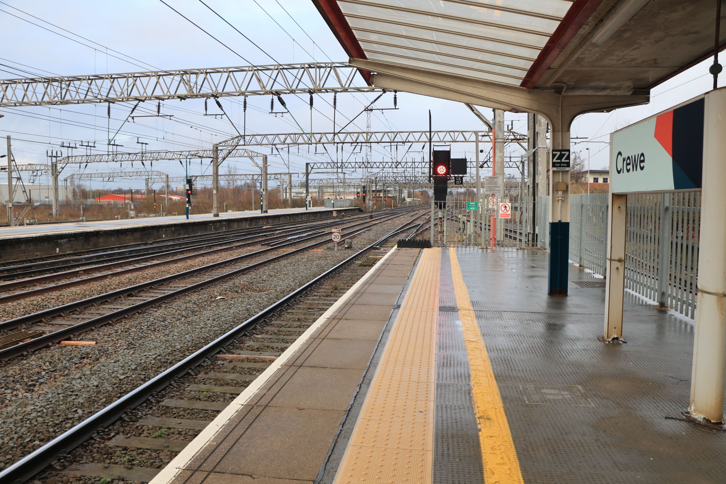 A platform at Crewe station with the station sign